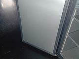 a refrigerator that is open on the floor in a room