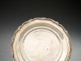 une assiette en argent avec un motif décoratif sur le bord