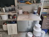 many buckets of paint on the shelves in the room