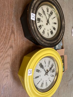 deux horloges posées par terre l'une à côté de l'autre