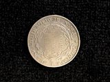 a close up of a silver coin on a black surface