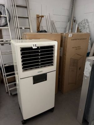 un climatiseur blanc posé dans une pièce où se trouvent de nombreux cartons