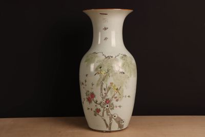 a white vase with a painting on it sitting on a table