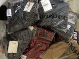 many bags of clothing that are wrapped in plastic