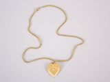 un collier en or avec un pendentif en forme de cœur sur une chaîne