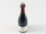 a close up of a bottle of wine on a white surface