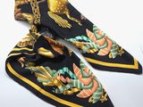 a black and yellow scarf with a bird design on it