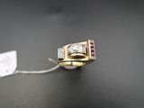 un gros plan d'une bague posée sur une table, avec une étiquette accrochée dessus