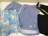 three men ' s swim trunks are lined up on a shelf