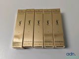 quatre boîtes de produits de beauté YSL posées sur une table blanche