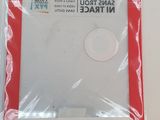 a white disk in a red package on a white table