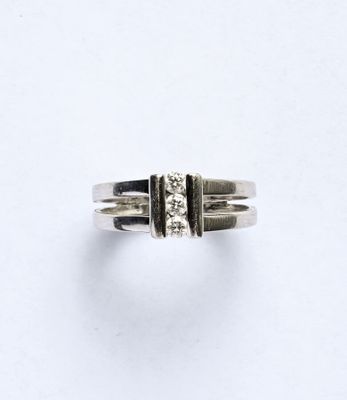 gros plan d'une bague en argent sur une surface blanche