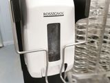 a white paper towel dispenser on a metal rack