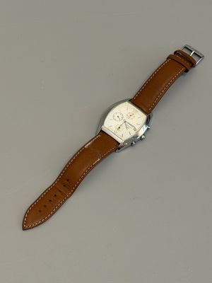 montre-bracelet avec un bracelet en cuir marron sur un fond gris
