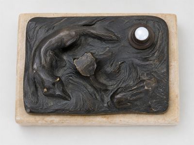 une sculpture représentant une femme tenant une perle dans la main