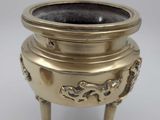 an image of a brass incense pot with a dragon design on it