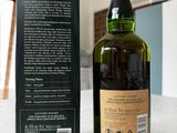 a bottle of whisky sitting on a table next to a box