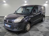 La petite camionnette grise est garée sur un sol en carrelage à damier.