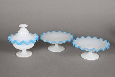 three white and blue glass vases sitting on top of a table