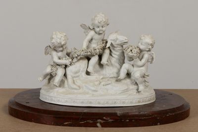 une statue représentant un groupe de chérubins posée sur une table