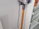 un aspirateur posé par terre à côté des toilettes