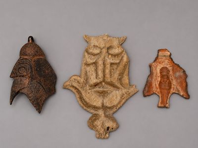 trois pièces en argile sculptée sont exposées sur une surface grise