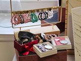 a table with a box of jewelry on it near a window