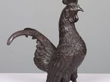 a bronze statue of a rooster on a white surface