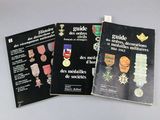 three books of military medals and medals on a white surface