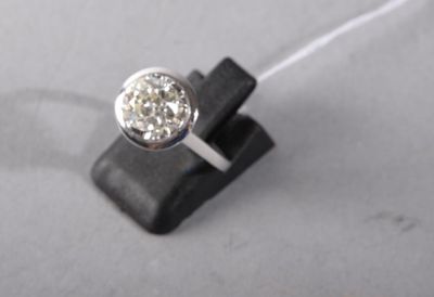 a ring with a diamond on top of a piece of wood