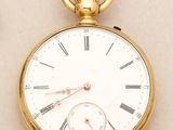 a gold pocket watch with roman numerals on it