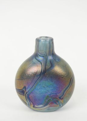 un vase bleu et violet posé sur une surface blanche