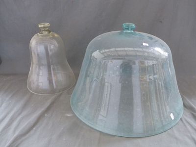 une cloche en verre et un récipient en verre posés sur une table