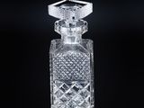 a close up of a clear glass perfume bottle on a black surface
