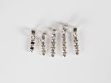 three silver charms with black and white stones on a white surface