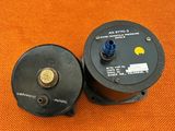 a couple of black and yellow water pumps sitting on top of a orange cloth