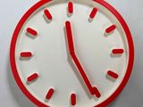 a red and white clock on a white wall