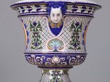 a blue and white vase with a face on it