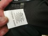 someone is holding a label on a black jacket with a white label on it