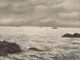 many boats that are out in the ocean on a cloudy day