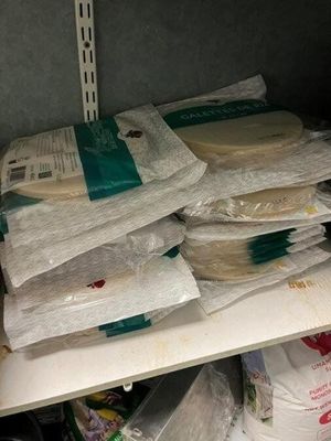 many bags of food sitting on a shelf in a refrigerator