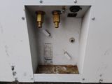 a picture of a white cabinet with two valves and a meter