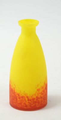 un vase jaune et rouge posé sur une surface blanche