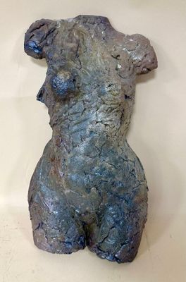 a sculpture of a woman that is sitting on a table