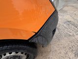 an orange car that is parked on the side of the road