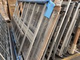 a lot of windows that are stacked up in a warehouse