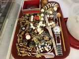 un plateau rouge rempli de bijoux variés posé sur une table