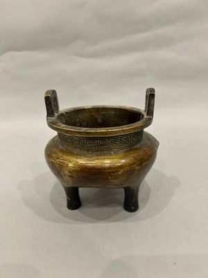 an old brass pot with a handle on a white background
