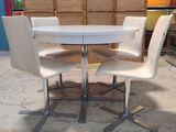 a white table with four chairs around it in a room