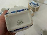 a person holding a small box with cups and saucers on it